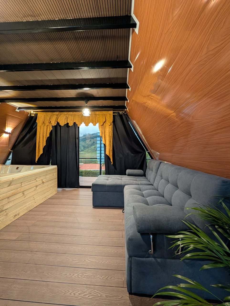 La sala con sofá en L y el jacuzzi frente a la montaña